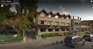 a building with a car parked in front of it at Depto Del lago, con la mejor vista y cercano a todo - Ayres del Bosque Alojamientos in San Martín de los Andes
