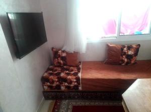 un letto e una sedia in una stanza con finestra di إقامة الصابرين تطوان a Tétouan