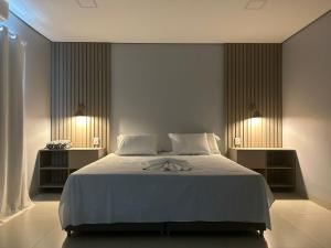 a bedroom with a large bed with two night stands at Hotel Vizon 3 in Vilhena