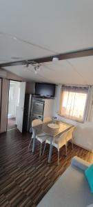 a kitchen and dining room with a table and chairs at Mobil home Camping Les Embruns 4 étoiles in Lège-Cap-Ferret