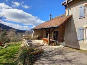 a house with a porch with a wooden bench at Gîte Les Ebeteux in Fraize