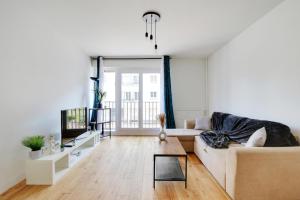a living room with a couch and a tv at Au pied de l'arche in Courbevoie