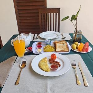 ウダワラウェにあるElegant HomeStayのテーブル(朝食用の食品プレート、オレンジジュース1杯付)