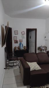 a living room with a brown couch and a chair at Casa lai in Rio de Janeiro