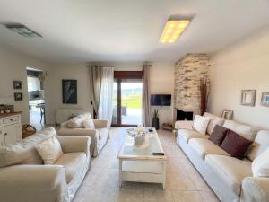 a living room with white couches and a fireplace at Boho Mare Retreat - Skala Fourkas in Skála Foúrkas