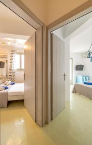 a bedroom with a bed and a sliding door at Villa Azallea by Mykonian Kazarte in Kalafatis
