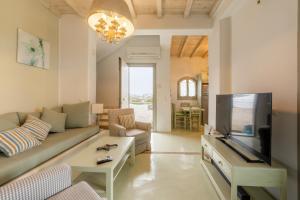 a living room with a couch and a flat screen tv at Villa Azallea by Mykonian Kazarte in Kalafatis