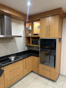 a small kitchen with wooden cabinets and a sink at Forest Home Accommodation in De Grendel