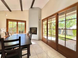 Maison 12 personnes max proche Mer et parkings gratuits في لو غراو دو روا: غرفة طعام بها طاولة وكراسي ونوافذ