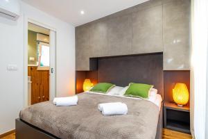 ein Schlafzimmer mit einem großen Bett mit zwei grünen Kissen in der Unterkunft Villa Royal Green Resort in Nona + 67 Fotos