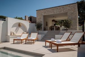 a group of chairs on a patio with a pool at Villa Sea Song in Tkon