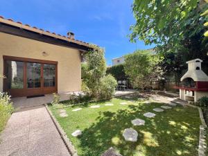 Maison 12 personnes max proche Mer et parkings gratuits في لو غراو دو روا: حديقة خلفية بها صخور في العشب