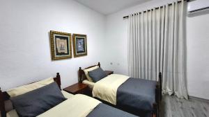 a bedroom with two beds and a window at Sweet Home in Pogradec