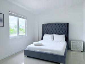 a bed in a white room with a window at Renzzi Villas in Miami