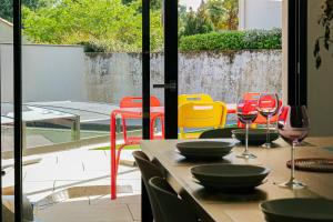 ein Tisch mit Stühlen und Weingläsern auf einer Terrasse in der Unterkunft Villa des Hérondais avec piscine - idéal familles - 8 personnes in Jard-sur-Mer