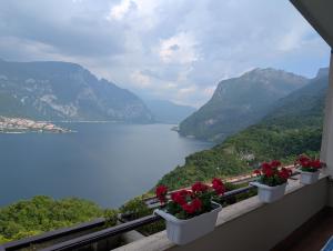 balkon z kwiatami i widokiem na jezioro w obiekcie Angolo Paradiso - Lago di Como w mieście Valbrona