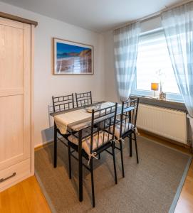 Un comedor con mesa y sillas y una ventana. en Wohlfühl-Appartement in Brilon, en Brilon 7 fotos más