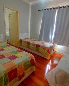 a bedroom with two beds and a mirror in it at Pousada Estação do Pedrão in Maria da Fé +48 photos