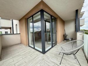 a balcony with a glass door and a chair at Apartament Wysockiego in Bielsk Podlaski