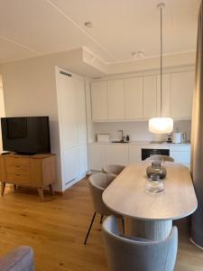 a kitchen with a table and chairs and a television at Sadama Apartment in Haapsalu