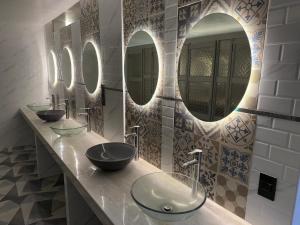 a bathroom with three sinks and three mirrors at Way Kap Hostel Arequipa in Arequipa +70 photos