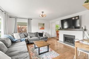a living room with a couch and a fireplace at Stunning Heritage Home, Sleep 10, Hot Tub, Private Yard, Firepit, in Vernon