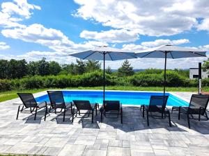 un patio con sillas y sombrillas junto a una piscina en Villa Sunset, en Banja Luka