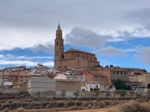 a city with a clock tower and a church at Cueva Colorin Alloza. in Alloza