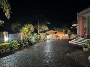 勒斯滕堡Private room in Rustenburg的夜间在房子前面的鹅卵石走道