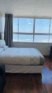 a bedroom with a bed and a large window at Accommodation Front - Edgy Beachfront 2 Sleeper with Stunning View in Durban
