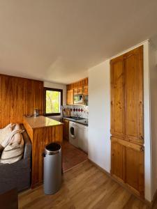 Una cocina con gabinetes de madera y encimera. en Soleil des Alpes, en Orcières 1 foto más