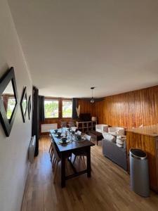 una sala de estar con una mesa y un sofá en Soleil des Alpes, en Orcières