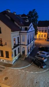 a car parked in front of a white building at Sowi Kąt CENTRUM in Mikołajki