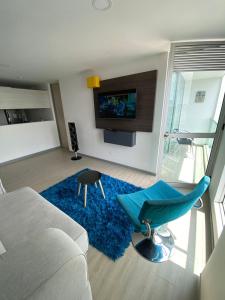 a living room with a couch and a blue rug at Apartamento in Pereira