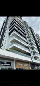 a tall building with a koku coffee sign in front of it at Apartamento in Pereira