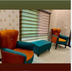 un salon avec deux chaises et un canapé dans l'établissement The Snug Spot, à Islamabad