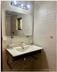 une salle de bain avec un lavabo et un miroir dans l'établissement The Snug Spot, à Islamabad