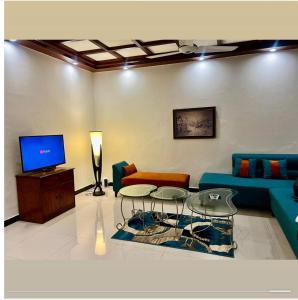 un salon avec un canapé et une télévision dans l'établissement The Snug Spot, à Islamabad