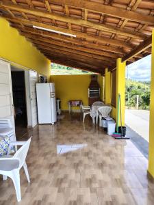 a room with a white refrigerator and tables and chairs at Pousada Recanto Dilello in Socorro