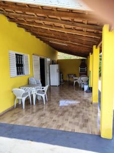 a patio with tables and chairs and a yellow wall at Pousada Recanto Dilello in Socorro +44 photos