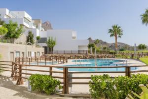 a swimming pool with chairs and a building at Casita San Juan in Pilar de Jaravía