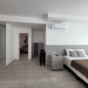 ボンビーニャスにあるResidencial Rota do Sol Bombinhas Centro 100 metros da praiaのベッドと机が置かれた寝室
