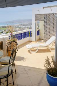 a balcony with chairs and a table and a view at The Rina Hostel in Agadir