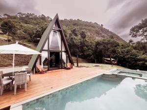 a small house with a pool and a wooden deck at Turisfri Resort in Nova Friburgo