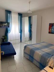 a bedroom with a bed and a chair and blue curtains at La casetta di Andreina in Sarzana