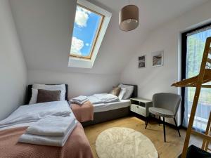 a bedroom with two beds and a window at Domek na Rybackiej in Swarzewo