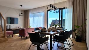a dining room with a table and chairs and a living room at Domek na Rybackiej in Swarzewo
