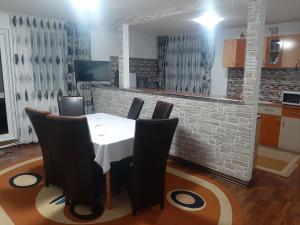 a dining room with a white table and black chairs at Casa Anastasia in Bicaz