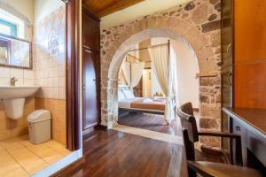 a bathroom with a stone archway and a sink at Traditional stone house Ariadne near Matala beach in Petrokefálion +80 photos