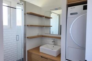 a bathroom with a sink and a washing machine at Les Semis in Soorts-Hossegor +7 photos